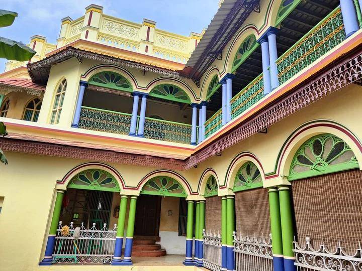 Colourful Chettinad mansion facade with arched verandah and green balustrades
